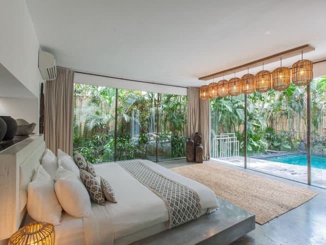 Inside of a bedroom overlooking a private pool at Kima Surf Camp, Bali