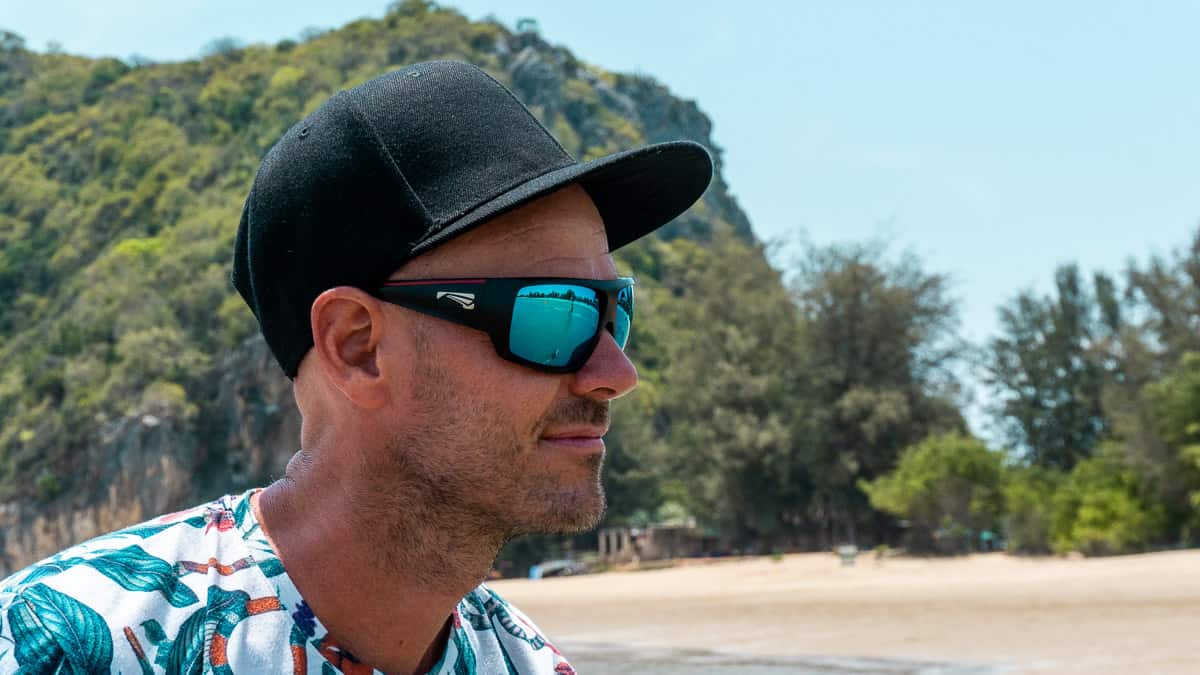 Mann am Strand trägt Qualitätssonnenbrille mit polarisierten Carl Zeiss-Gläsern