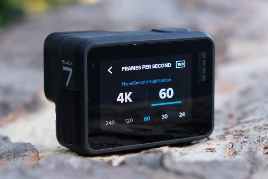 a close up of a gopro with the screen showing the interface to choose image resolution. the screen reads "4k / 60 fmps"