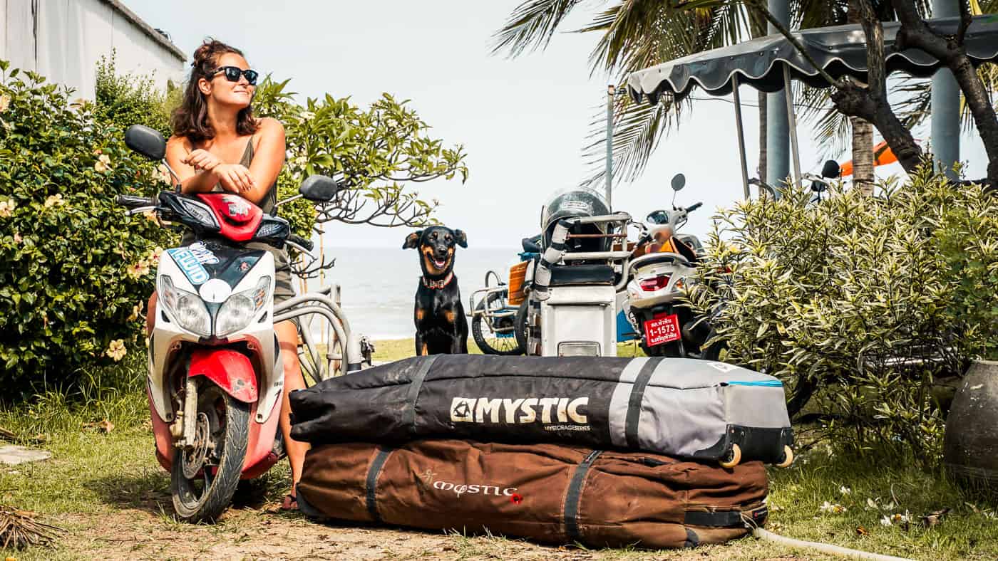 Two kiteboard bags loaded onto a saleng (sidecar in Thailand) driven by a lady and her dog