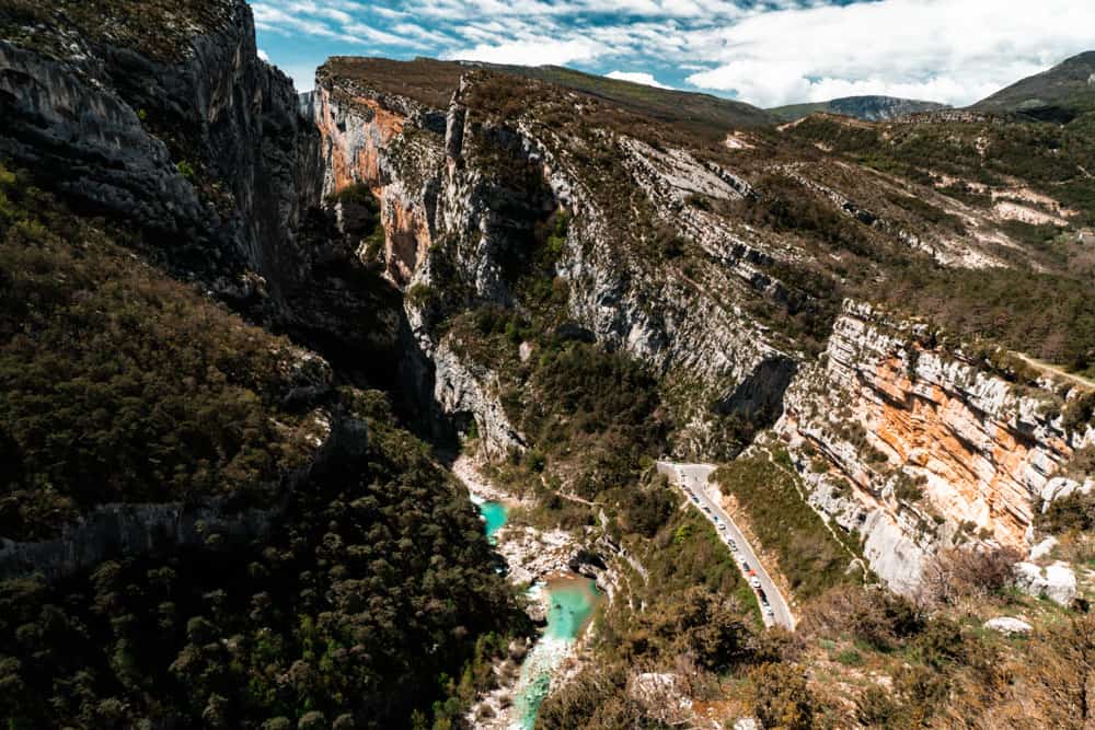 Die Verdon-Schlucht vom Aussichtspunkt 'Point Sublime', der in der Nähe der Route Napoleon verläuft. Die Schlucht ist von einem türkisfarbenen Fluss halbiert, ein blauer Himmel über uns.