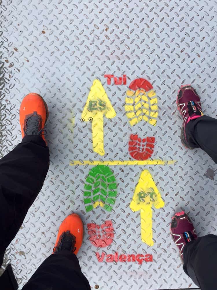 feet crossing the border between spain and portugal