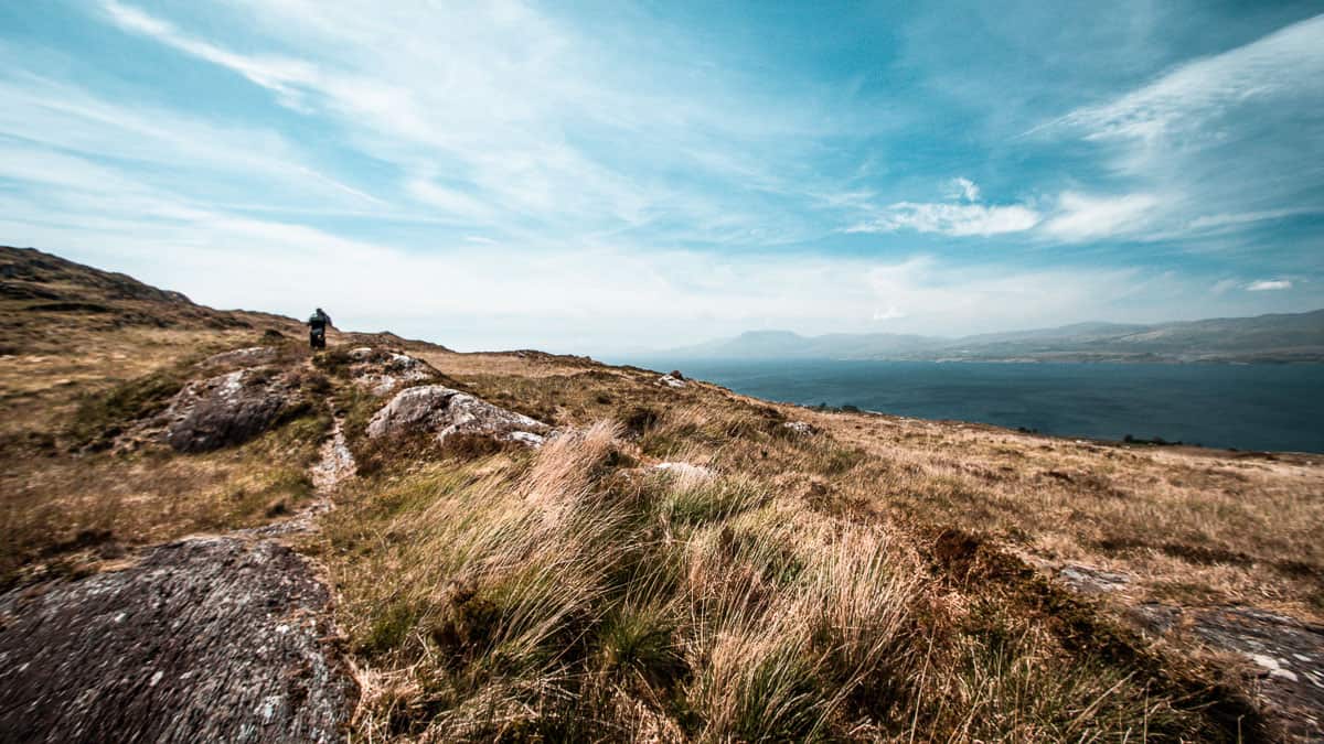 grand ciel bleu sur des montagnes accidentées avec l'eau bleue de la baie de bantry en arrière-plan