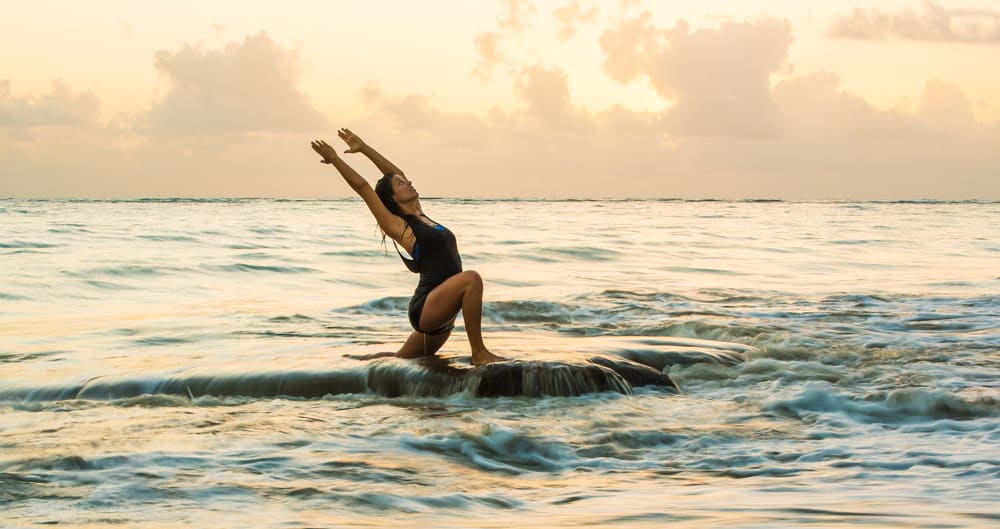 Frau macht Yoga in den Ufern des Strandes in Cabarete