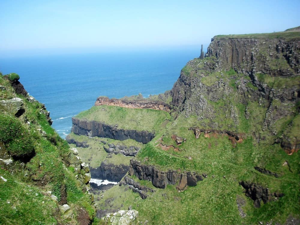 falaises de bord de mer face aux eaux bleues de l'atlantique sur la côte de Causeway, comté d'antrim, irlande