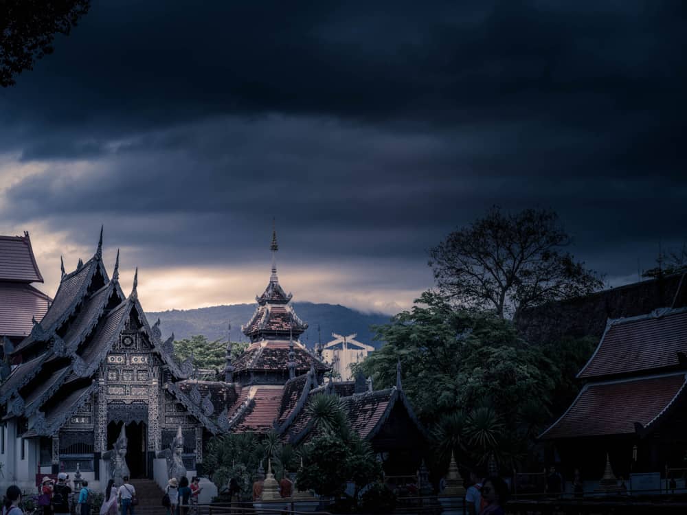 eine dunkle stimmungsvolle szene eines tempels in chiang mai, thailand, unter einem himmel voller schwarzer sturmwolken