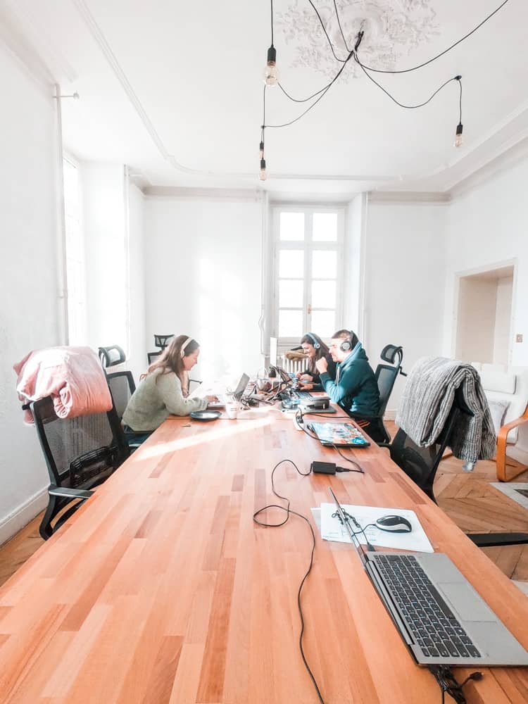 the coworking room in cloud citadel. there are three people working on their laptops wearing headphones.