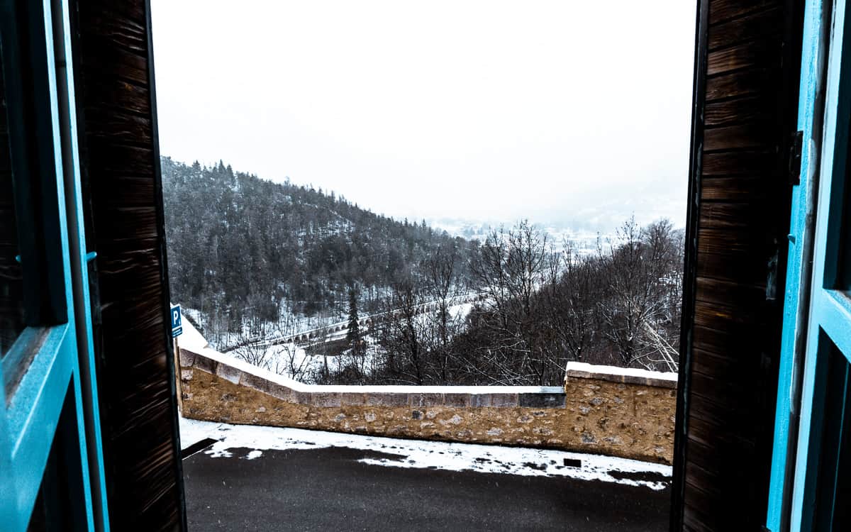 shuttered windows flung open to reveal the snowy landscape of briancon, serre chevalier.