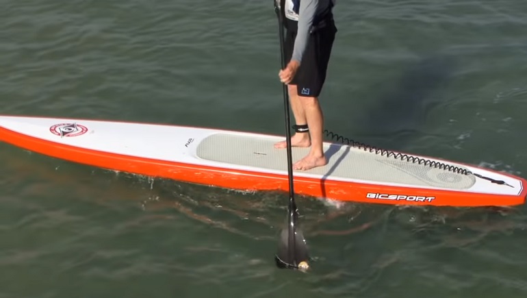 Surfbrett und Stand Up Paddle am Strand im Sommer.